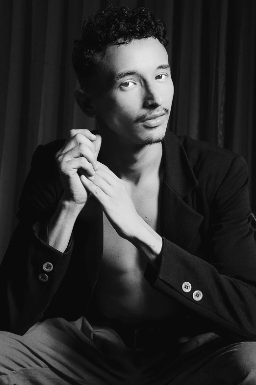 a man sitting on top of a bed wearing a tie