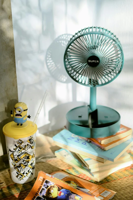 a table with a book and a fan on top