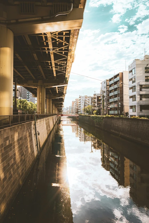 a body of water under a bridge next to buildings