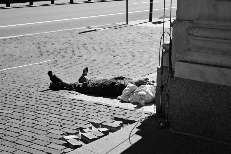 a person lays on the sidewalk near a crosswalk