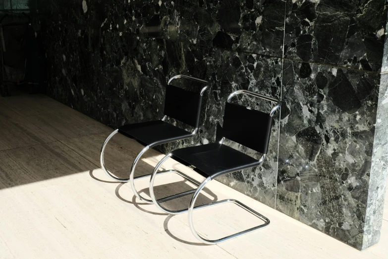 a pair of chairs in front of a wall