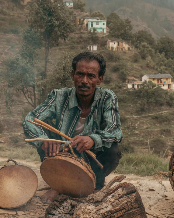 a man sits in front of a large pot