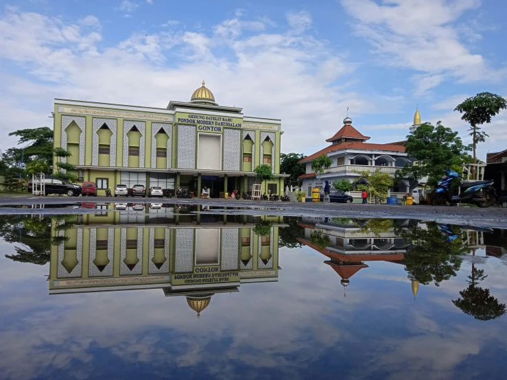 buildings line a street in an area that is reflective in the water