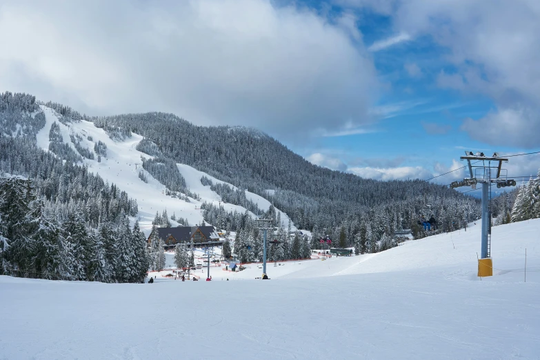 a ski slope with skiers on it and snow covered mountains in the background