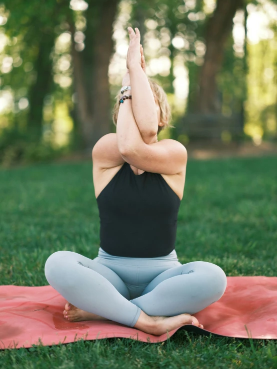 woman practicing yoga in a park by herself