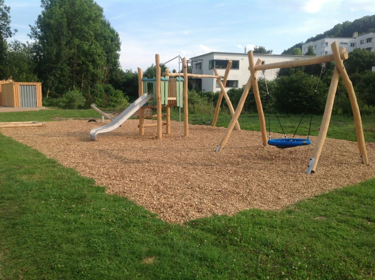 a play area with a slide, a swing set and a slide