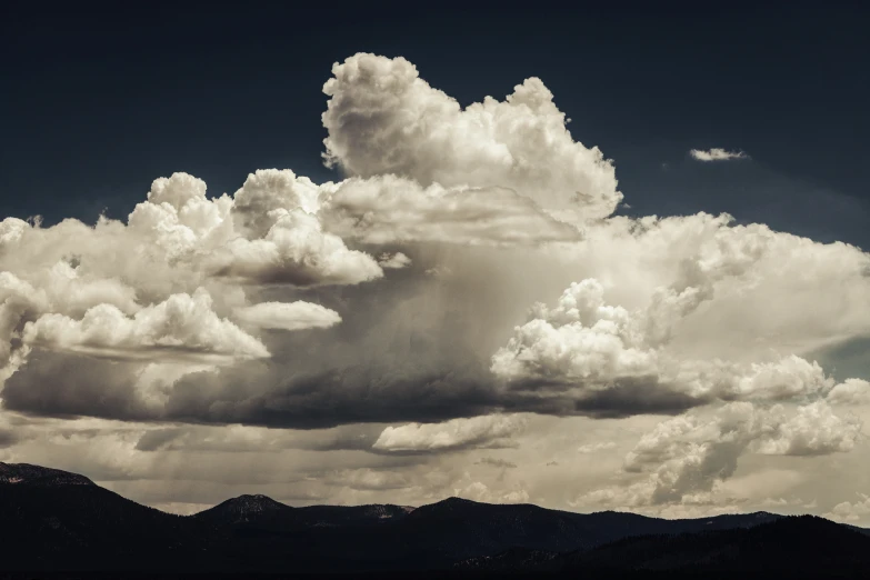 the clouds are in front of a mountain range