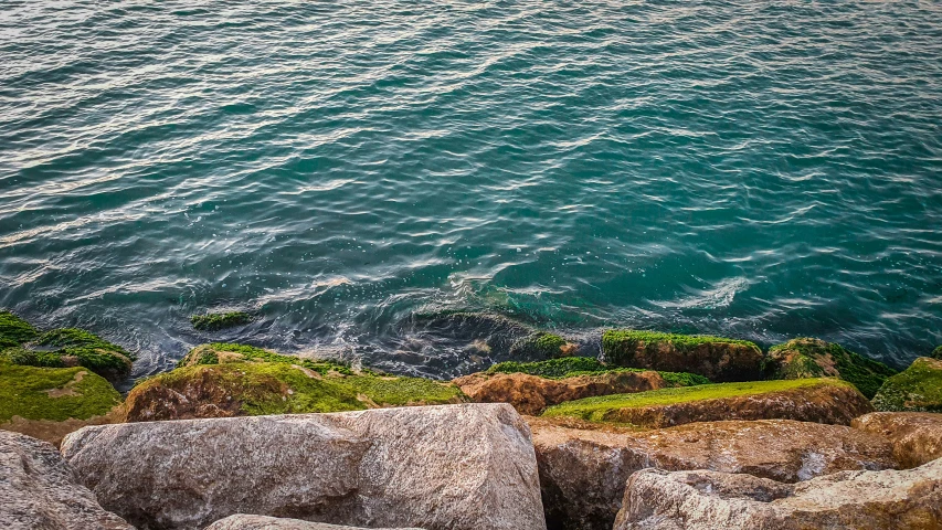 a body of water sitting next to some rocks