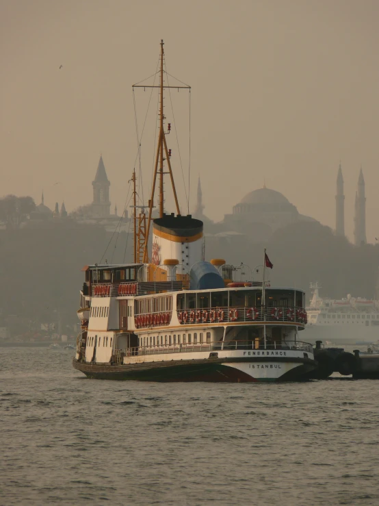 a large boat floating through the ocean next to a large building