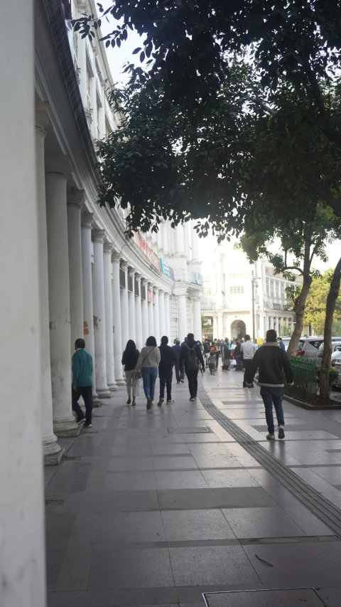 a city street that has pillars with pillars and people walking on them