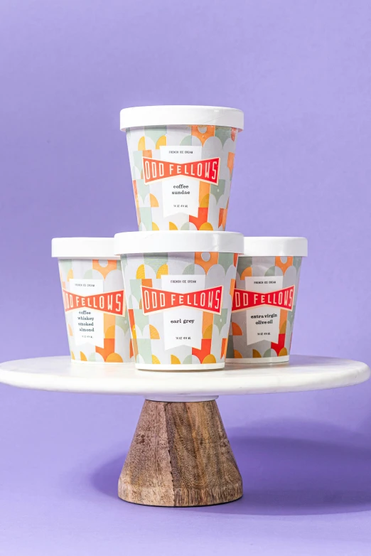 six ice cream containers sit on a plate