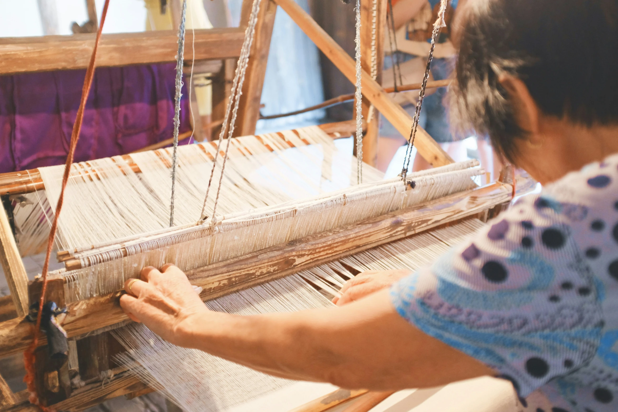 a woman is working on the weaving process