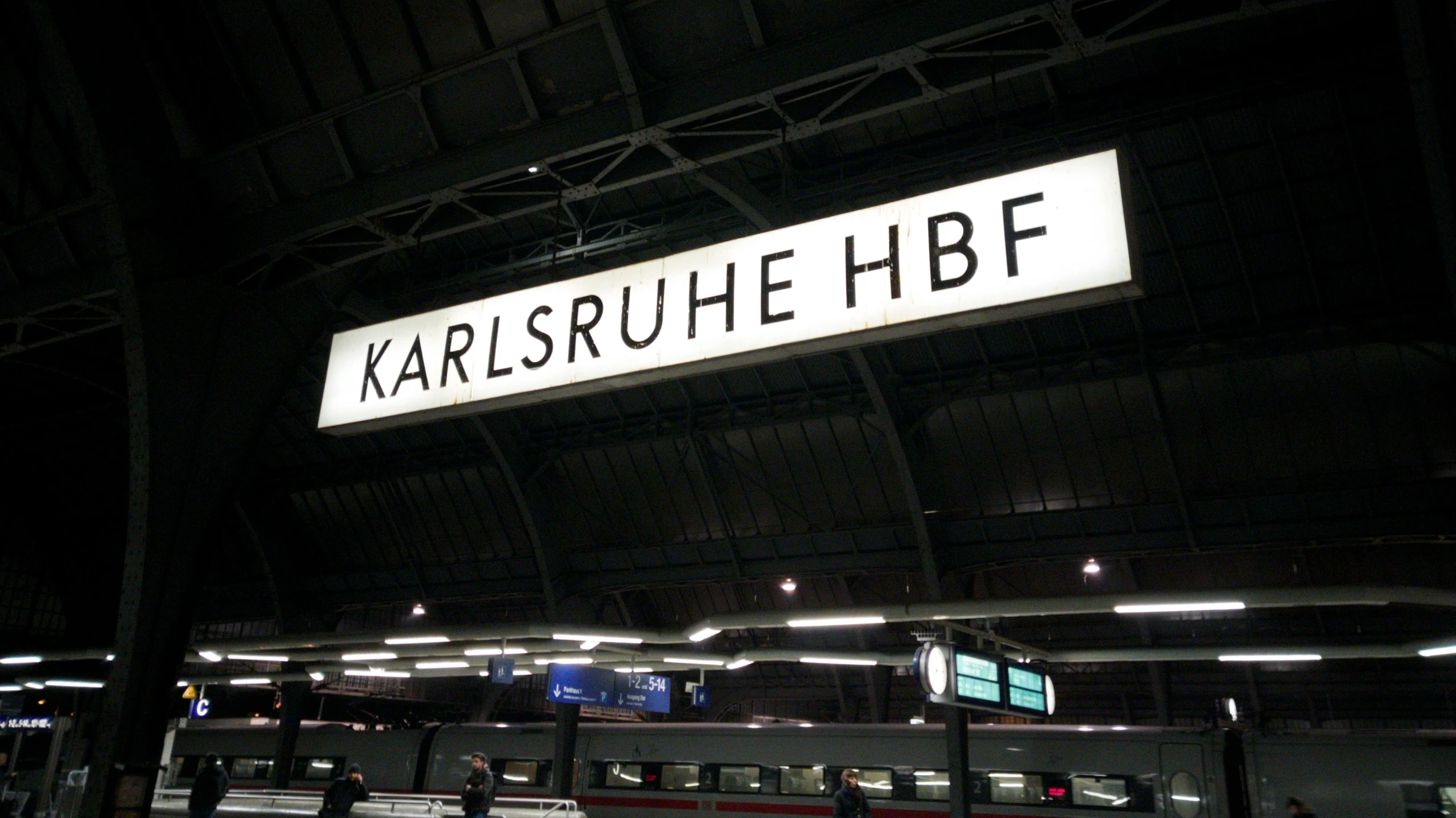 a train station with people waiting for the next train