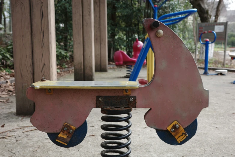 a pink swing sitting in the middle of a park