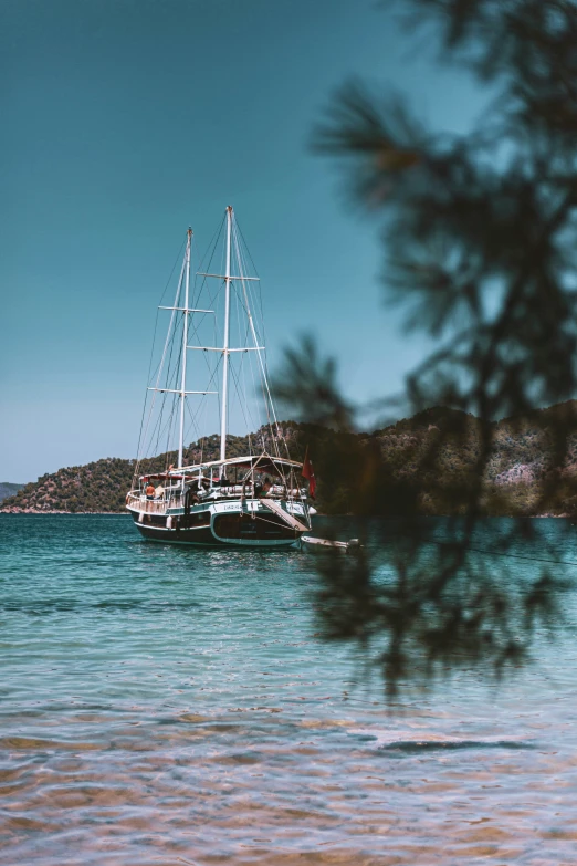 a sailboat floating in the water near shore