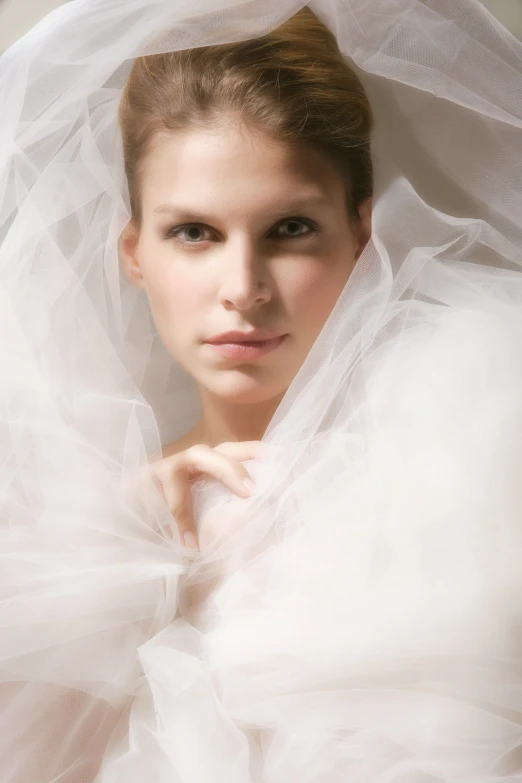 a woman in white veil with her hands on her chest