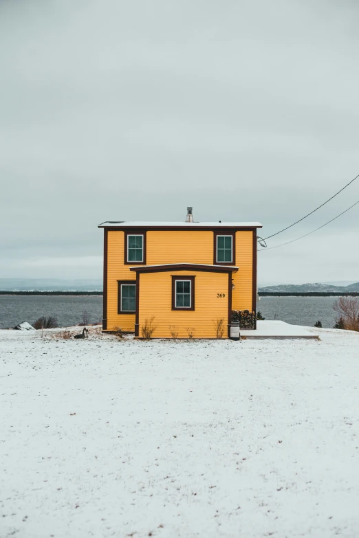 a house that is next to the ocean in the snow