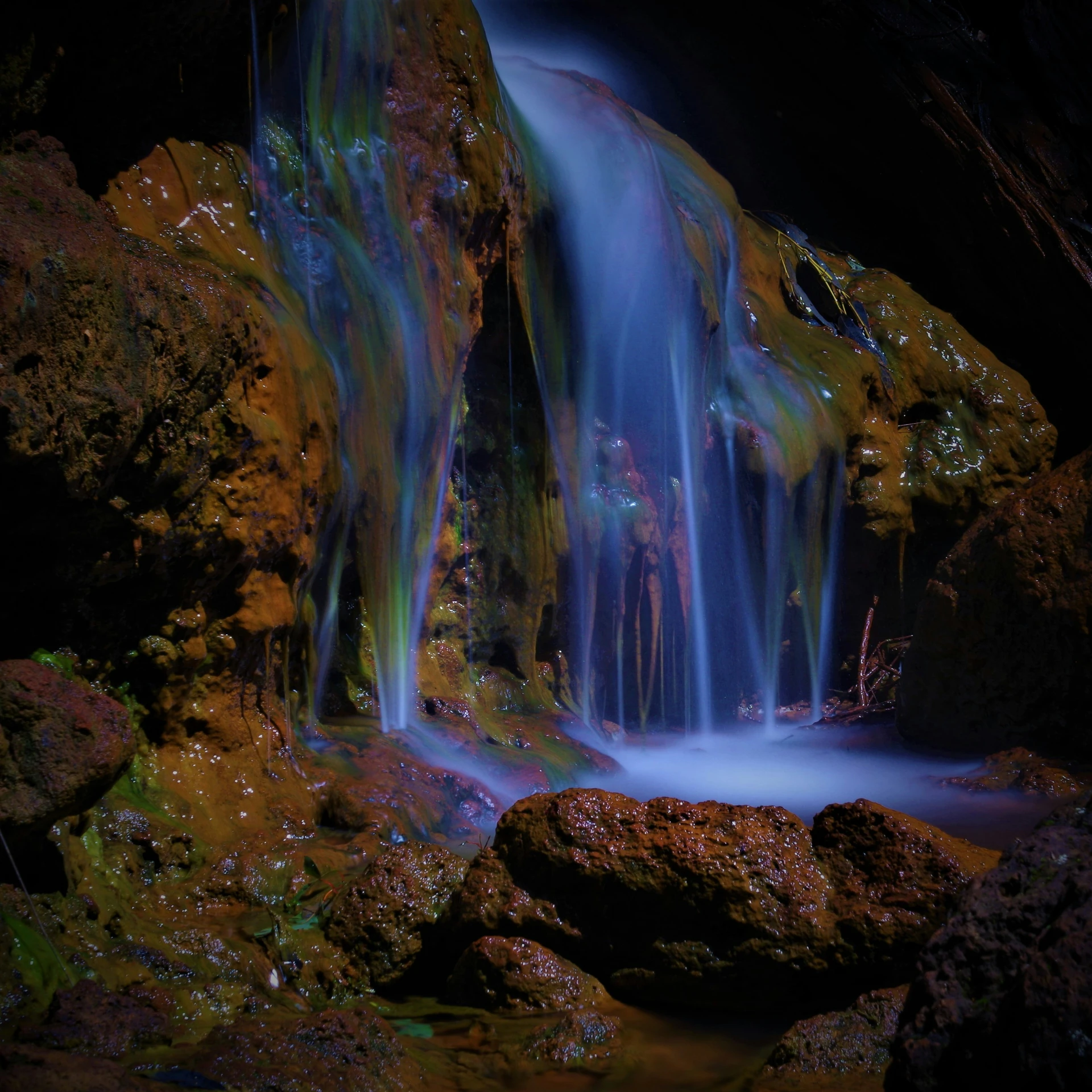 a view of a waterfall from the rocks