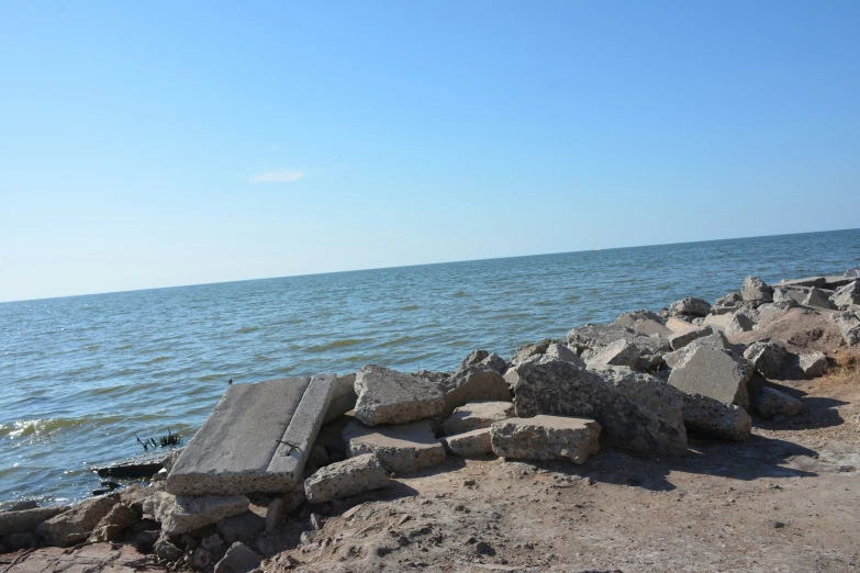 a cement bench on the shore next to water