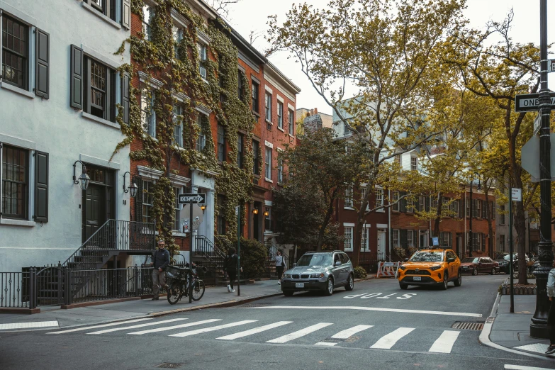 people standing and walking across the street in a small city