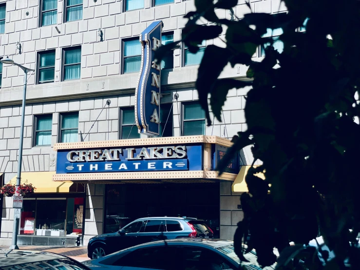 a theater sign sits on the corner of a street