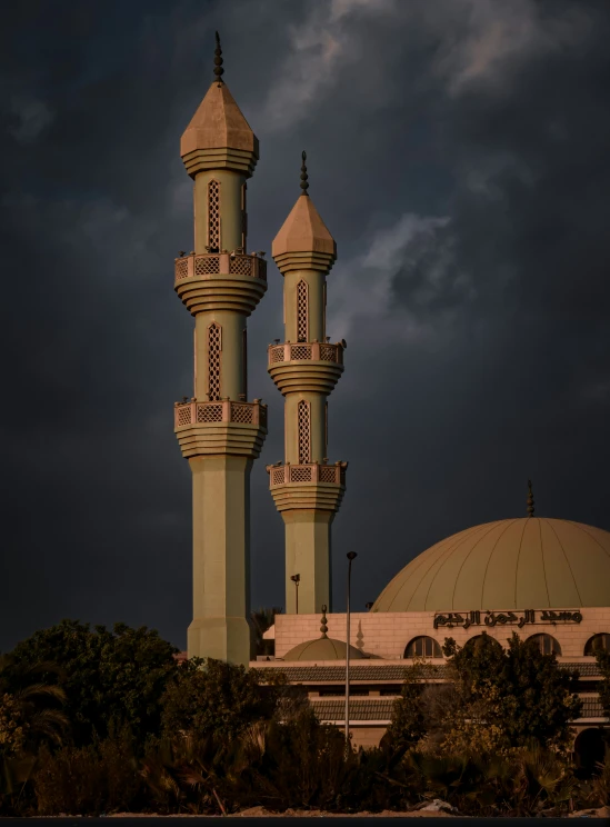 an outdoor area featuring two white towers and black clouds