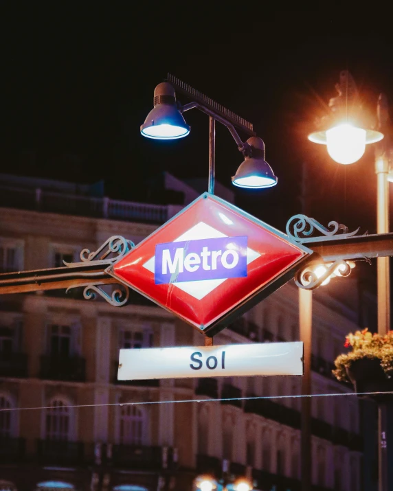 a metro sign that is hanging from the side of a building