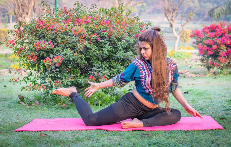 a girl practices yoga in the park