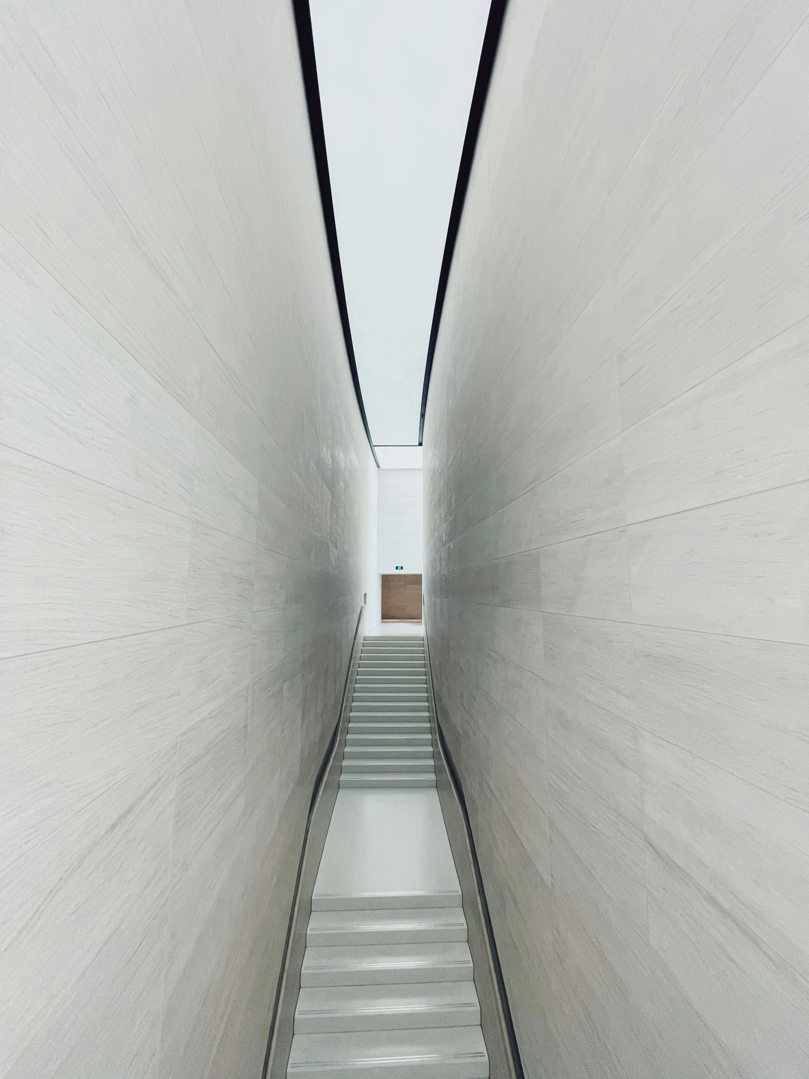 white steps in a concrete stairway between two walls