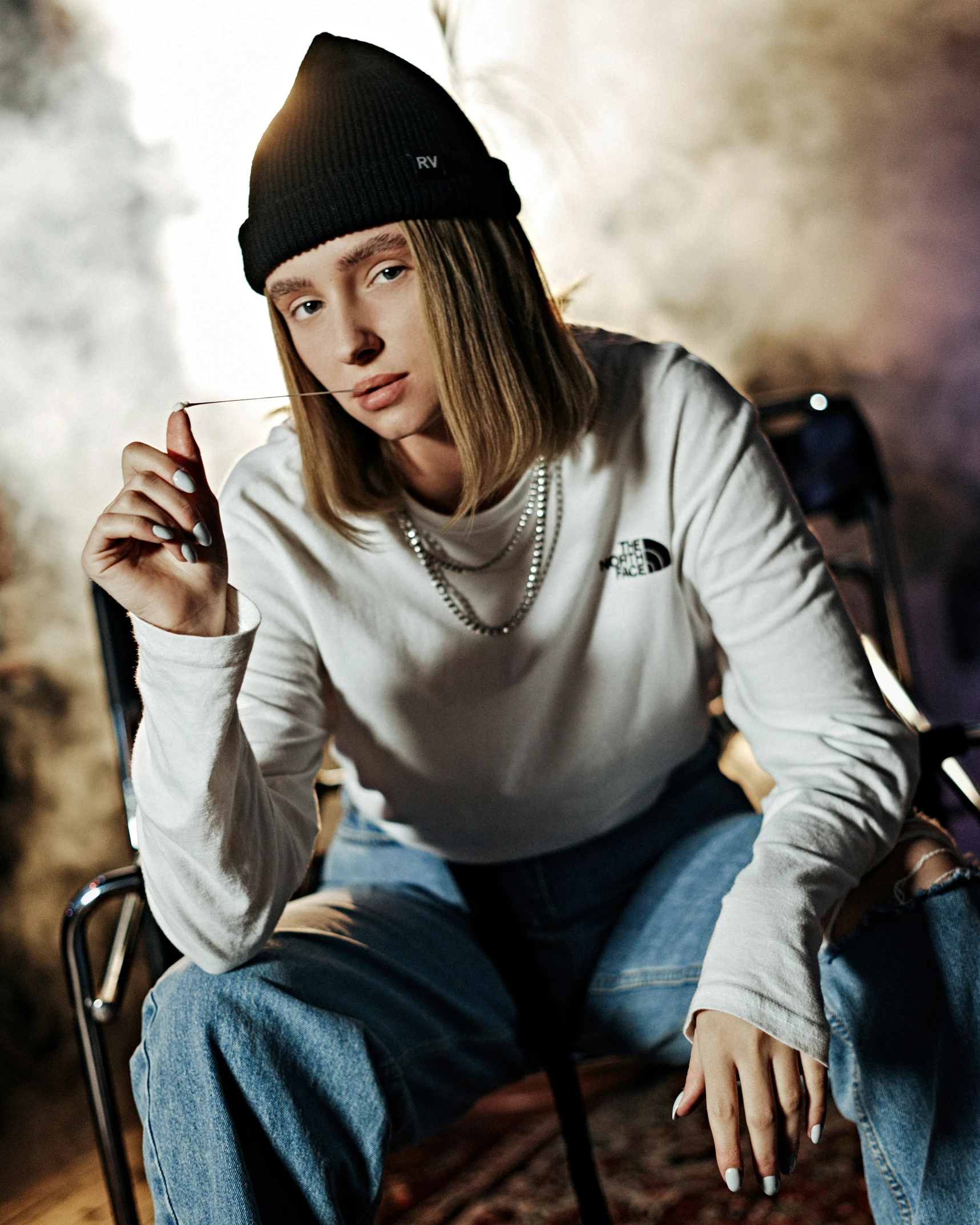 a woman sitting on a chair holding a cigarette