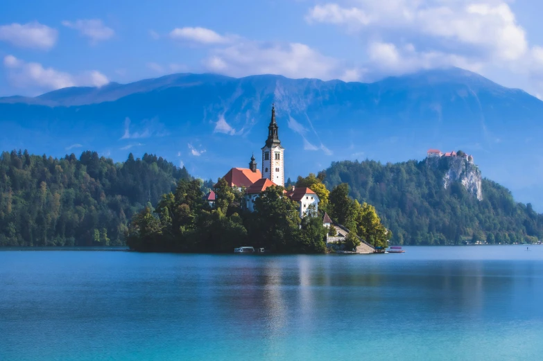 a small island in the middle of water with mountains on either side