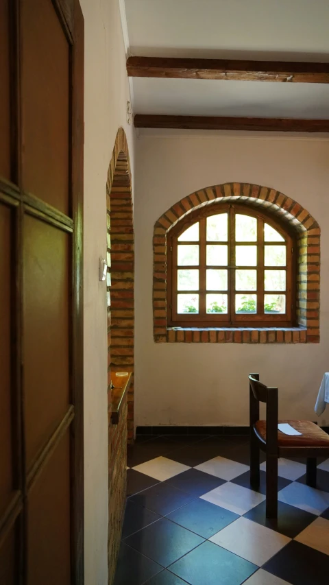 a room with two benches and an arched window