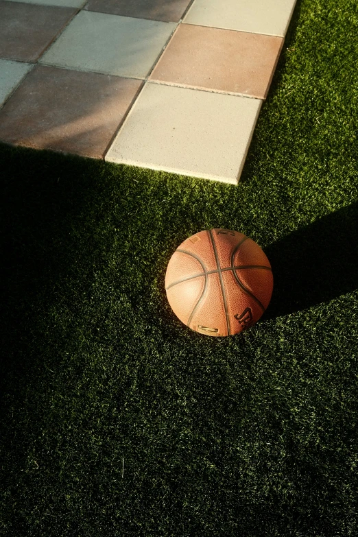 basketball on the ground next to a checkered surface