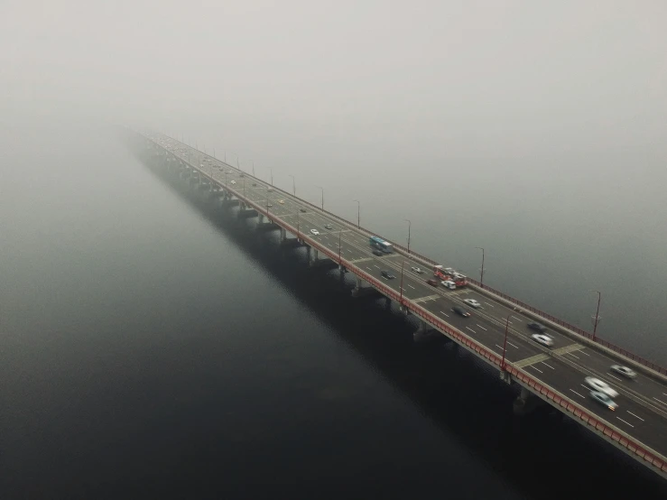 a bridge spanning across a river on a foggy day