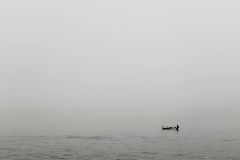 man in canoe in the middle of a large body of water
