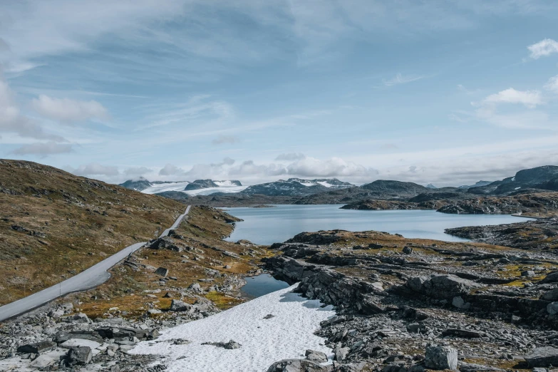 a road that is surrounded by snow and rocks