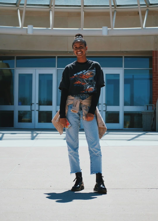 a woman standing outside of a building on a sunny day