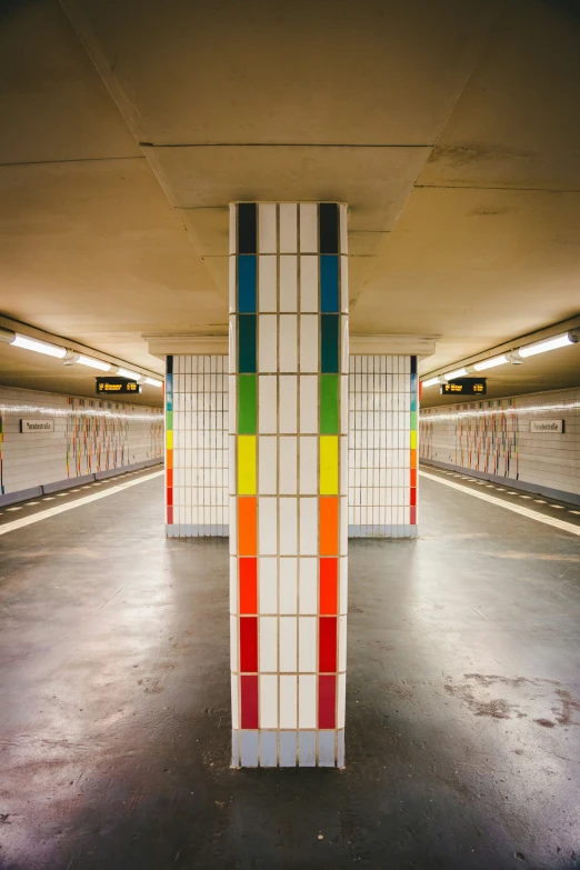 an empty subway stop with colorful painted columns