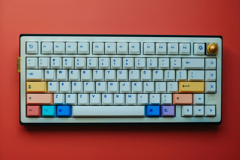 a keyboard with colorful keys sitting on a red surface