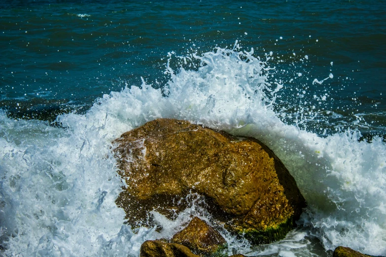 the waves crash on the rocks in the ocean