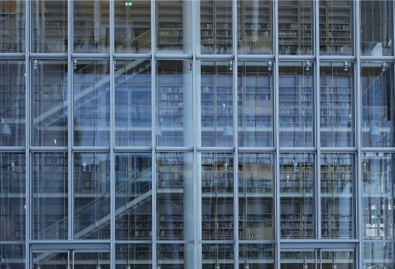 a tall glass building with metal spiral staircases