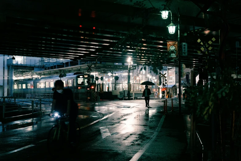 two people on bicycles in a train station at night