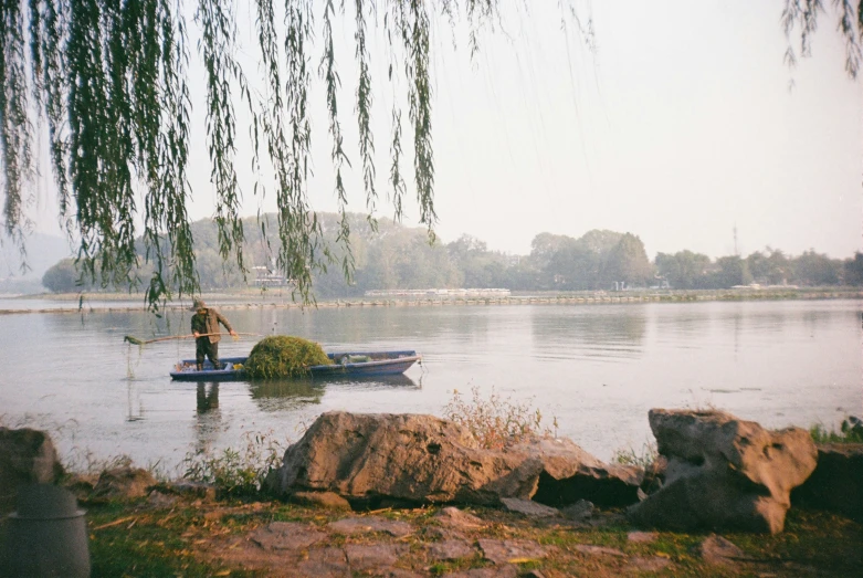 person paddling small motorboat on large body of water