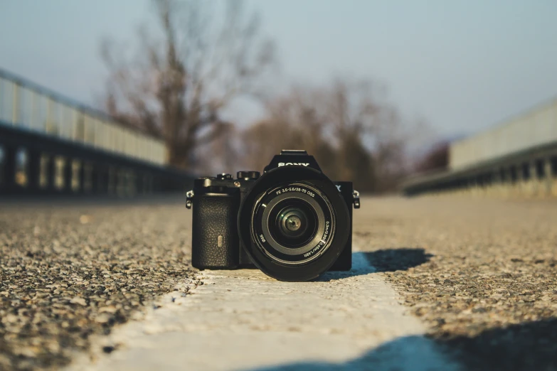 a camera sitting on a road near a railing