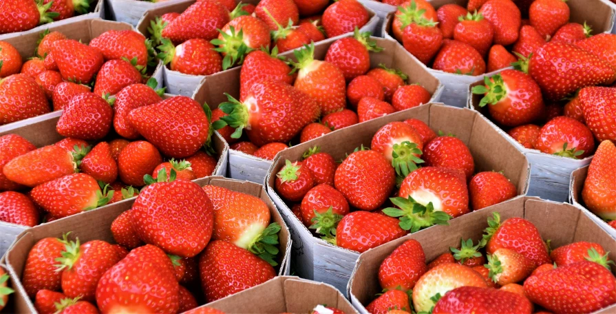 a pile of boxes filled with lots of red strawberries