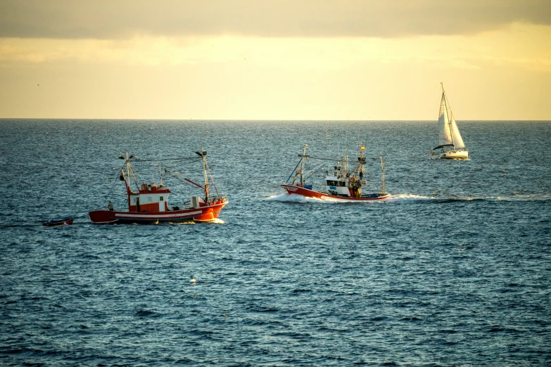 there are two boats in the ocean with sails on