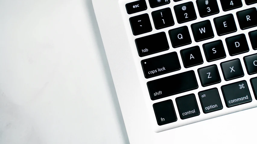 closeup of the keyboard and bottom cover of a white laptop