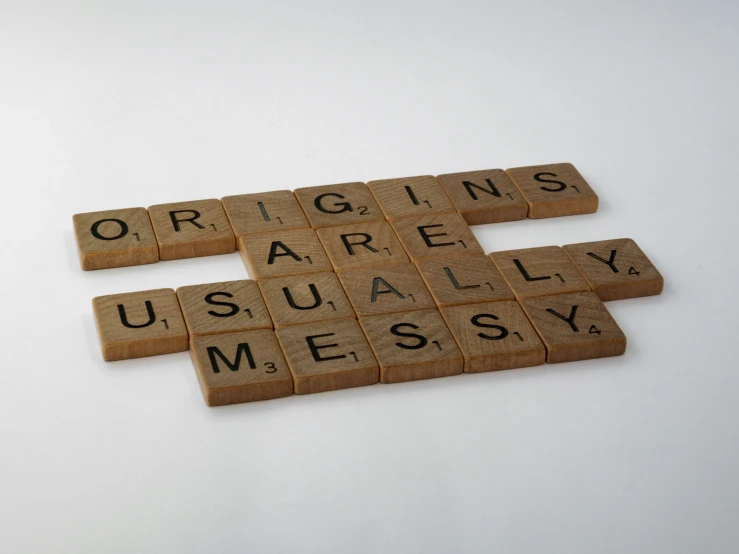 a group of scrabble letters that say origins, apparently measy