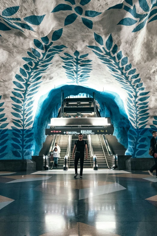 the interior of an underground subway station with people entering and going