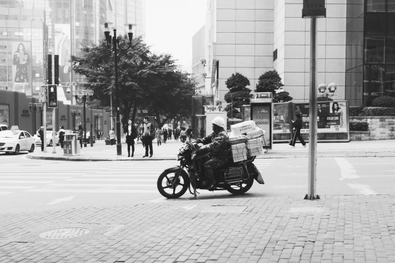 an image of a man on a motorcycle carrying stuff